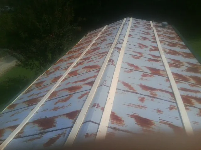 Rusted metal roof panels with new wood purlins before replacement — Storm Damage Roof Repair in Blockton by Roofing Brothers