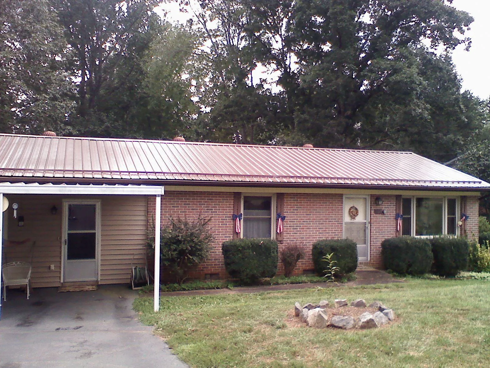 Bronze metal roof and carport on a brick ranch home — Roof Repair work by our crew in Blockton